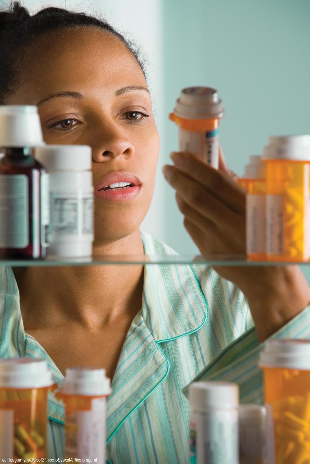 foto de una mujer inspeccionando medicamentos en el gabinete